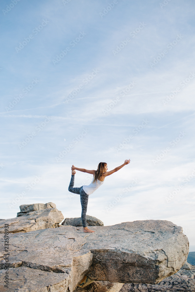 Woman stretching in yoga pose on mountain Woman stretching in yoga pose on mountain