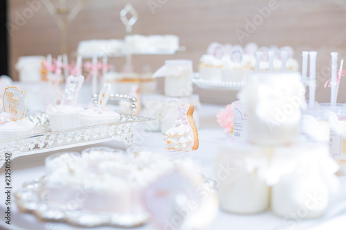 The dessert table has cream cakes, cookies, pudding