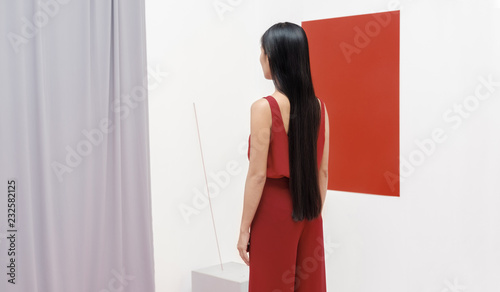 Asian fashionable female model with long hair in red in abstract space ./Fashion series