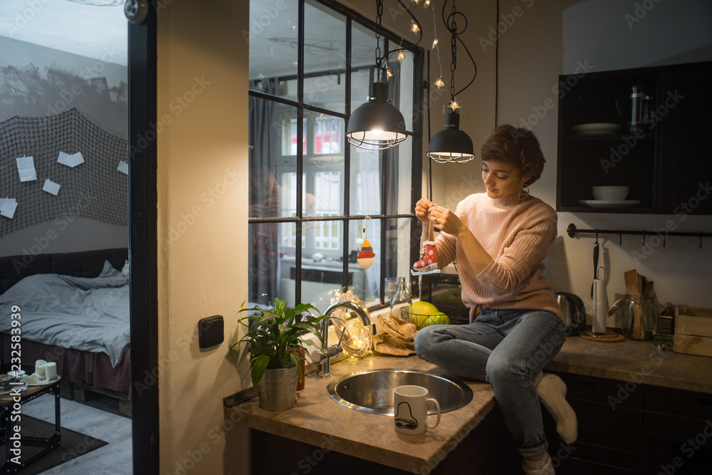 Young woman decorating kitchen for Christmas Young woman decorating kitchen for Christmas