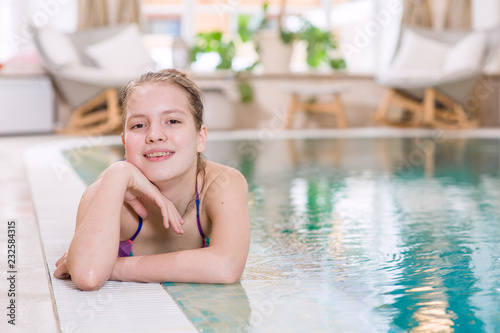 Happy teen girl lies near the pool