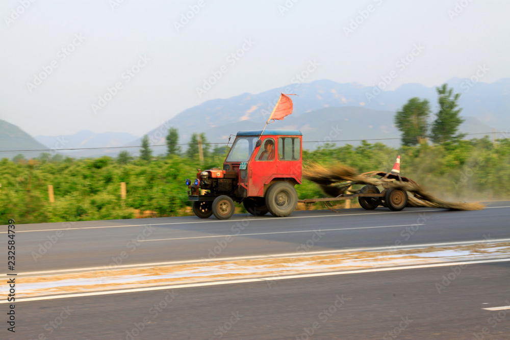 Small tractors are cleaning the health on the road, China...