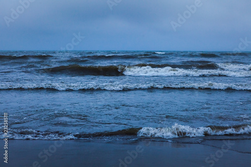 Dramatic foaming splashing waves in stormy weather background