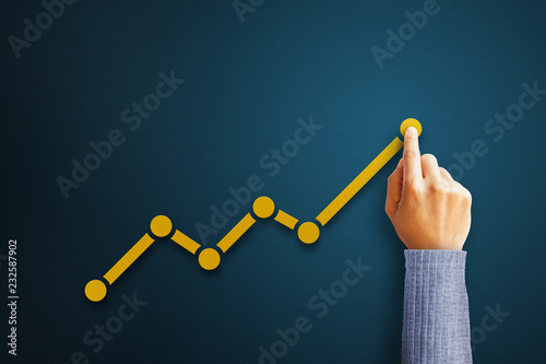 Businessman is touching arrows pointing up with graph as a symbol of growth and success or rising successful development and business development in the future photo