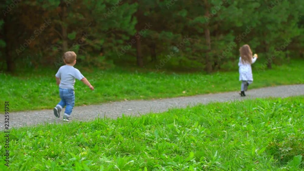 boy and girl running through the Park boy and girl running through the Park