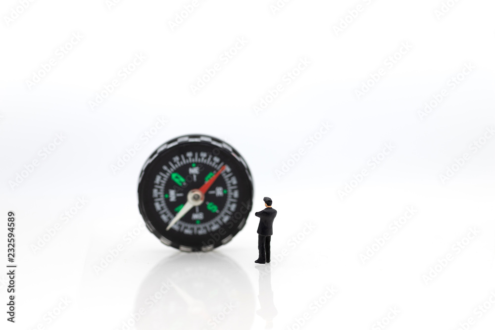 Miniature people : businessman standing with compass. Image use for business concept. Miniature people : businessman standing with compass. Image use for business concept.