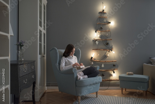 Beautiful caucasian woman unwrapping Christmas presents