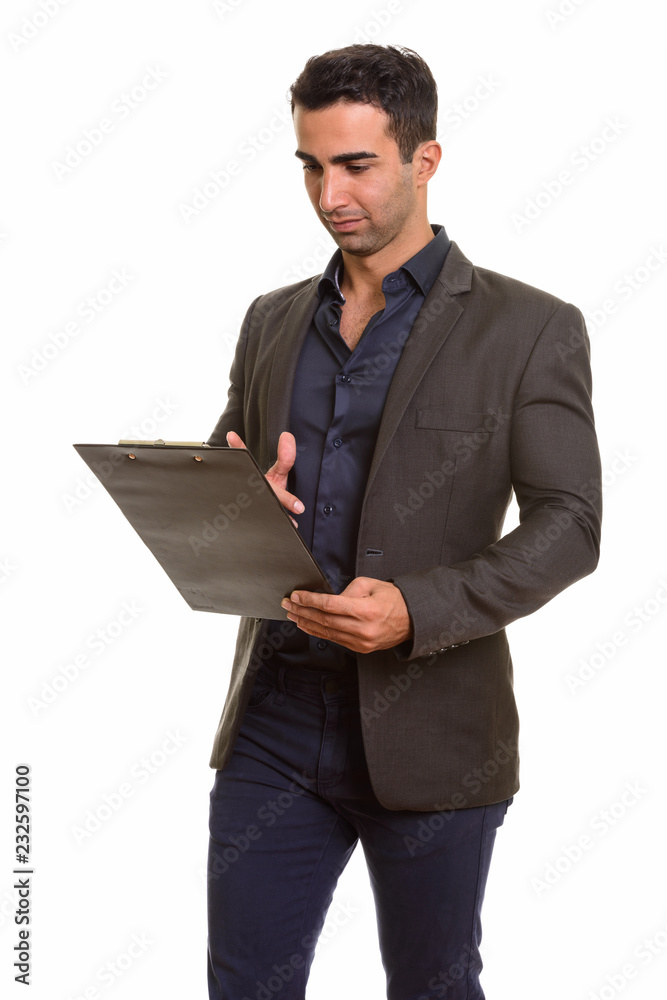 Portrait of young handsome Persian businessman with clipboard Portrait of young handsome Persian businessman with clipboard
