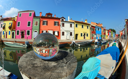 houses on the island of Burano near Venice in Italy and a glass sphere with the reflection of the village photo