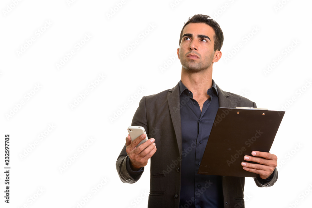 Persian businessman using phone and holding clipboard Persian businessman using phone and holding clipboard