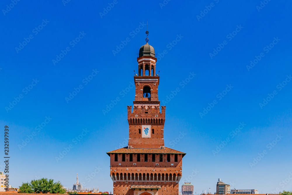 Tower of Sforzesco Castle under blue sky in downtown Milan, Italy