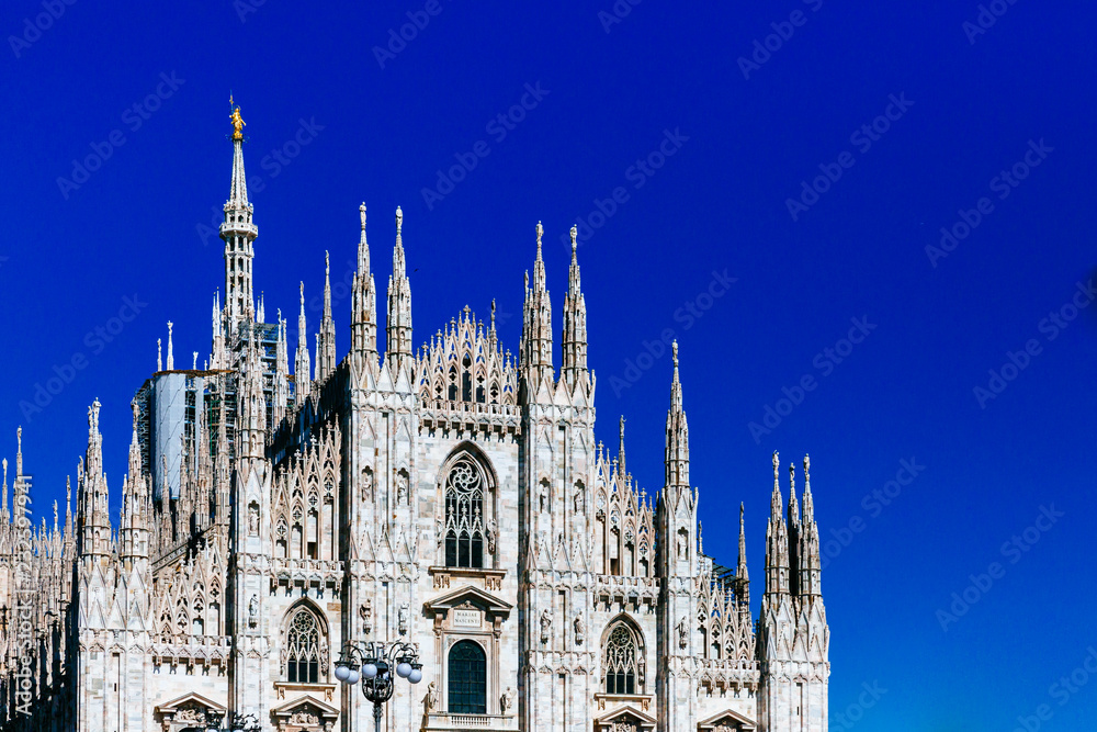 Facade of the Milan Cathedral under blue sky in the historical center of Milan, Italy