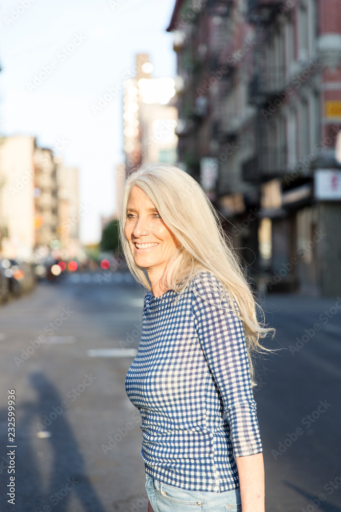 Woman walking outside at sunset smiling and having a good time