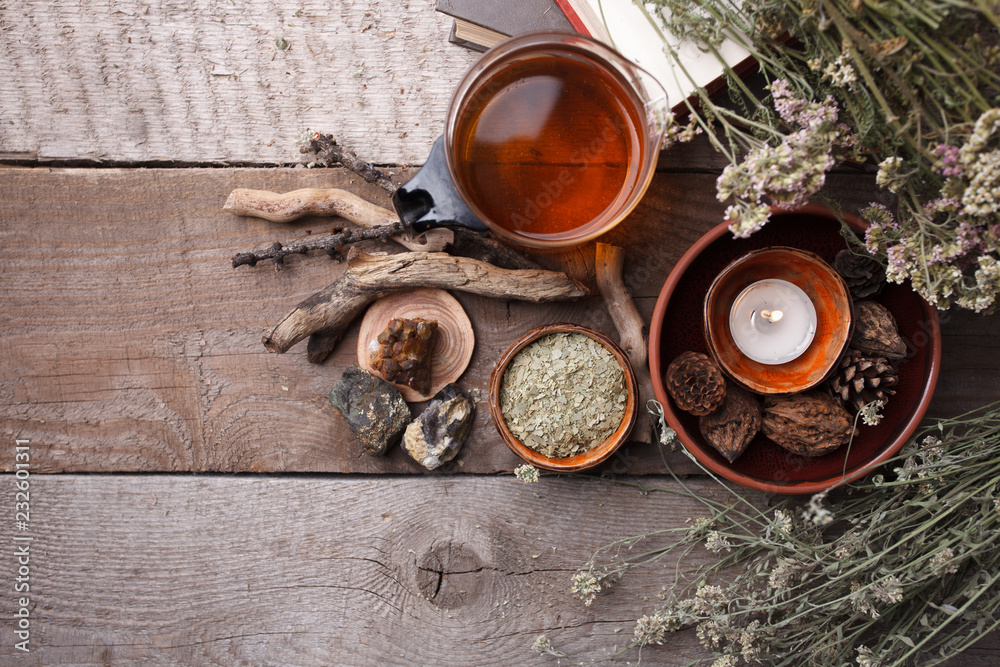 Authentic interior details, glass of herbal rea, homeopathic treatment on rustic wooden background top view, alternative medicine, healthy closeup Authentic interior details, glass of herbal rea, homeopathic treatment on rustic wooden background top view, alternative medicine, healthy closeup