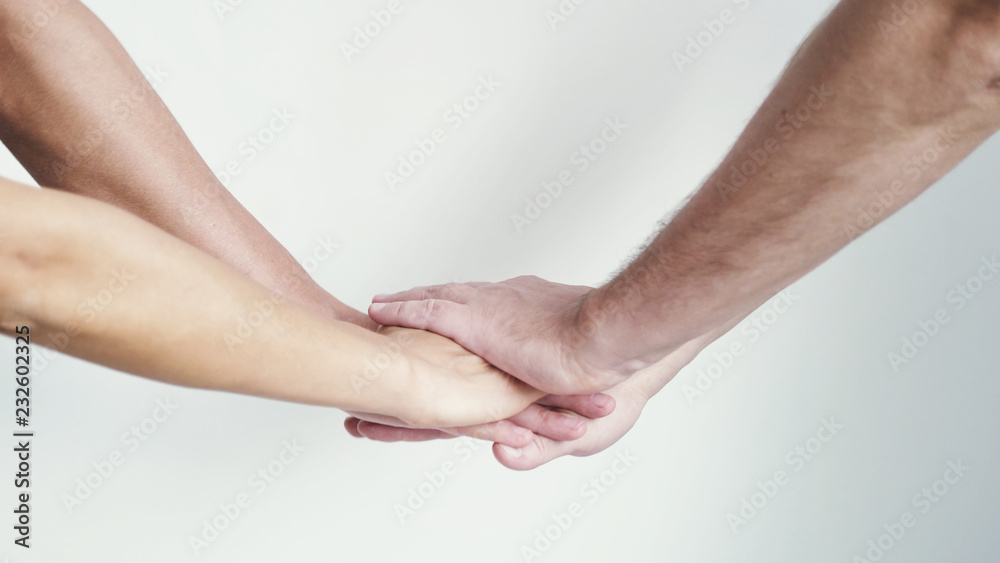 Three hands getting together on a white background. Close up Three hands getting together on a white background. Close up