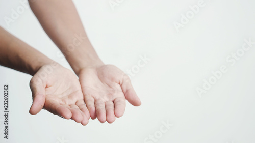 Putting female hands together and showing them towards camera on a white bakground
