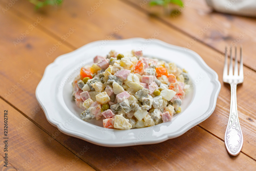 Traditional Russian salad on a wooden table Traditional Russian salad on a wooden table