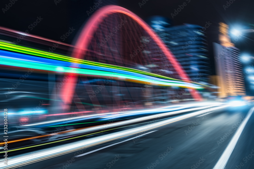 Fototapeta premium car light trails on steel bridge with city skyline.