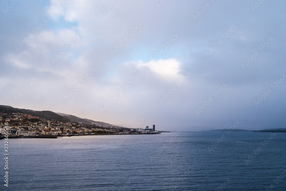 Norwegian City view to Molde from the sea side with fog at the background during winter