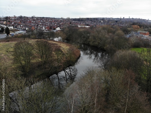 Aerial photo over looking a river canal showing autumn trees with brown leafs
