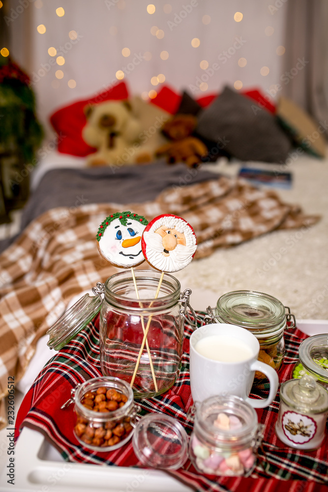 Gingerbread snowman and Santa on a stick on the breakfast table in the bedroom. Holiday sweets. New Year and Christmas theme. Festive mood