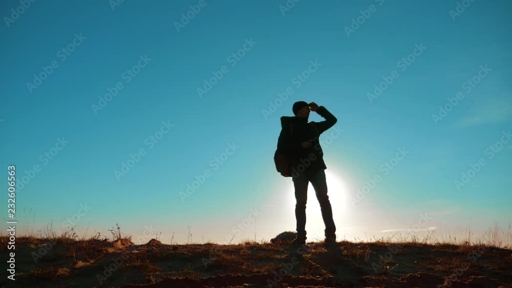 Male man worth it tourist with backpack smartphone navigation sunlight stands on top of a mountain. slow motion video. man silhouette at sunset. hikers adventure and lifestyle the go walking. travel Male man worth it tourist with backpack smartphone navigation sunlight stands on top of a mountain. slow motion video. man silhouette at sunset. hikers adventure and lifestyle the go walking. travel
