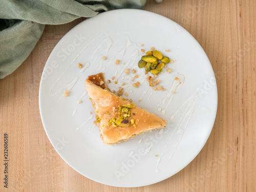 Mediterranean dessert of baklava made with chopped nuts, phyllo dough, and sweetened with a honey syrup. Surrounded with pistachios. photo