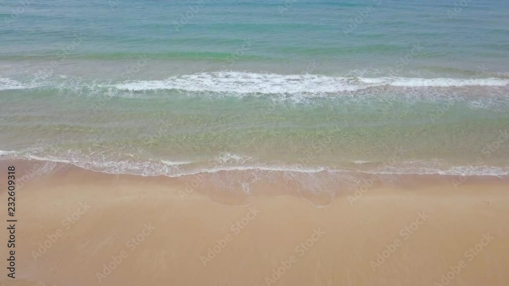 Beautiful clean empty beach with small waves breaking on the sandy beach - Aerial footage. Beautiful clean empty beach with small waves breaking on the sandy beach - Aerial footage.