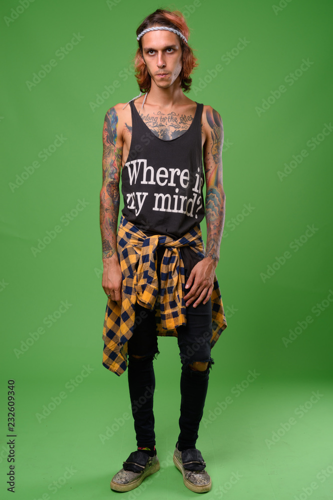 Studio shot of rebellious young man against green background Studio shot of rebellious young man against green background