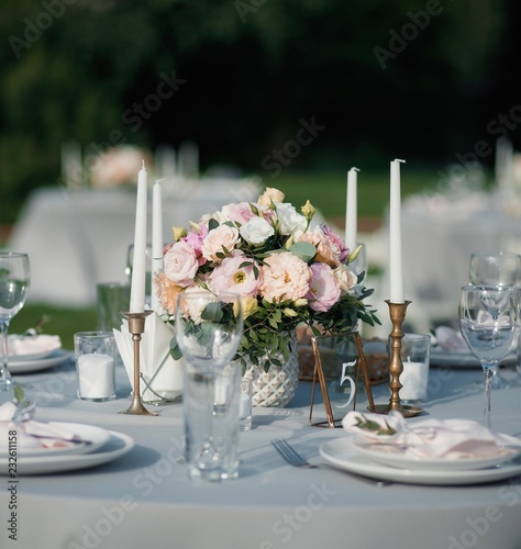 elegant table setup alongside with some candles in blue pastels for wedding and a number 5 sign