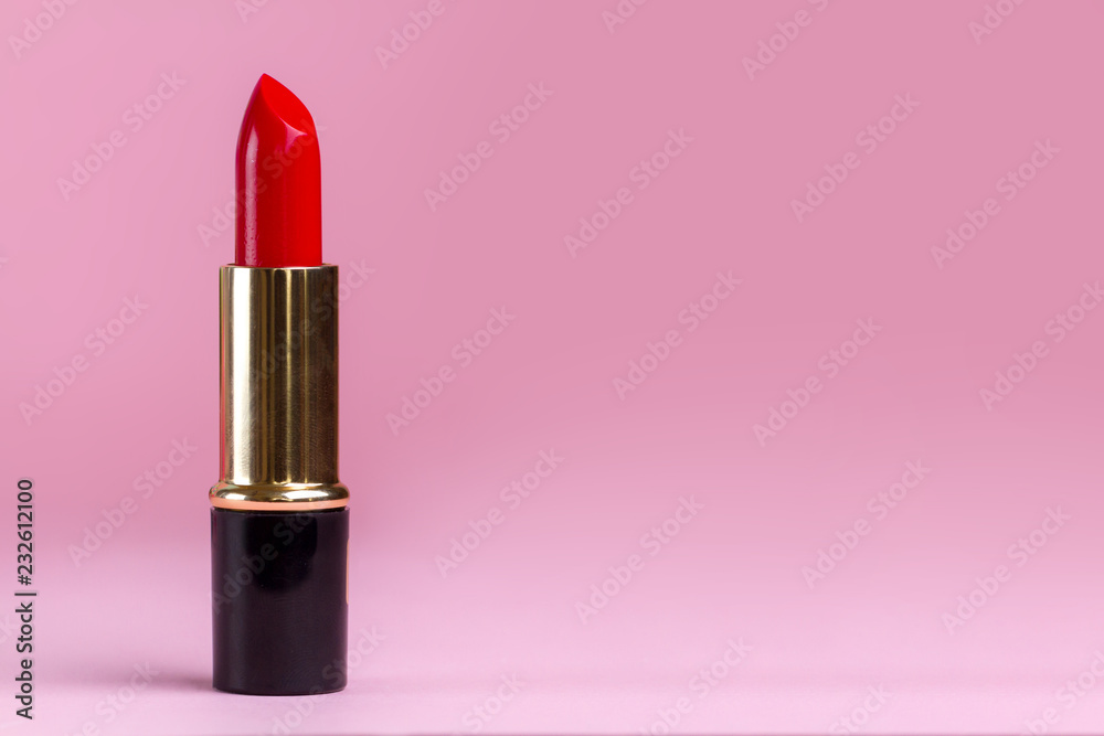 Red lipstick close-up on a pink background. Women's cosmetics for professional makeup. Copy space Red lipstick close-up on a pink background. Women's cosmetics for professional makeup. Copy space