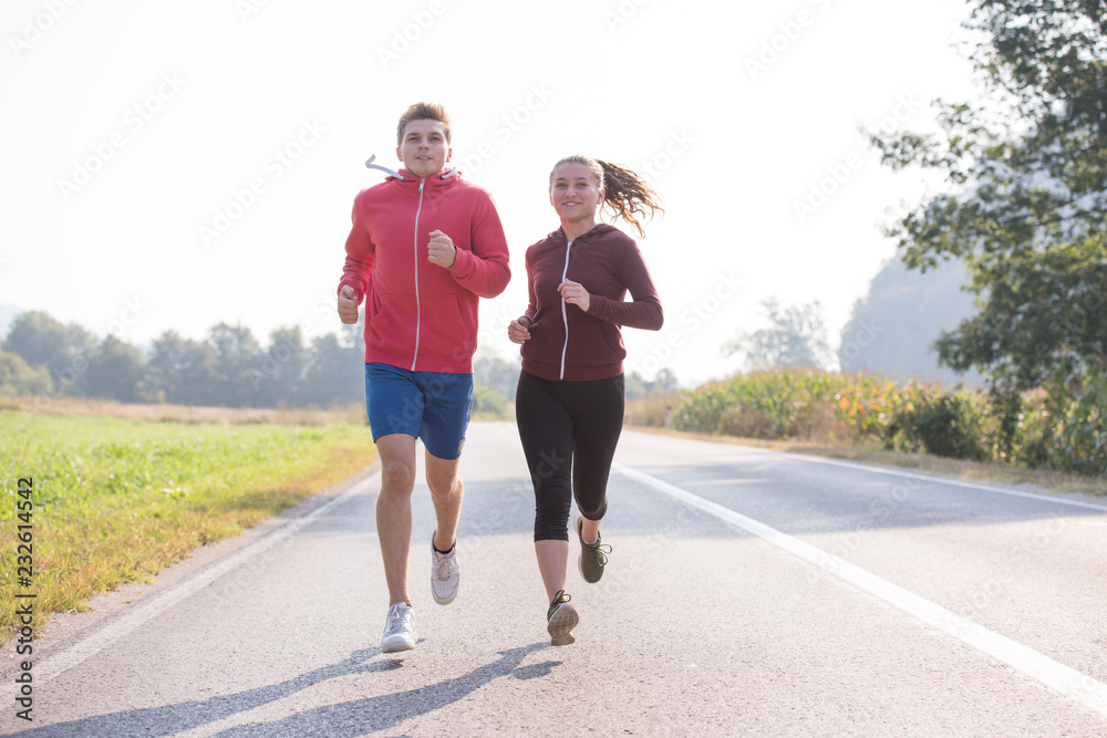 Fototapeta premium young couple jogging along a country road