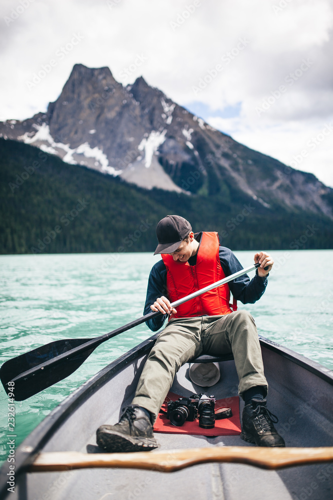 Young Adventurer Enjoying his Kayak Ride Through a Scenic Lake Young Adventurer Enjoying his Kayak Ride Through a Scenic Lake