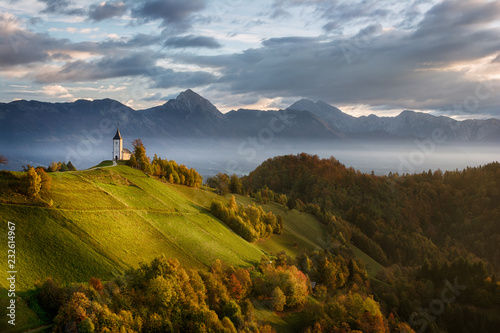 Beautiful sunrise landscape of church Jamnik in Slovenia with blue cloudy sky