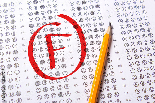Bad grade F is written with red pen on the tests photo