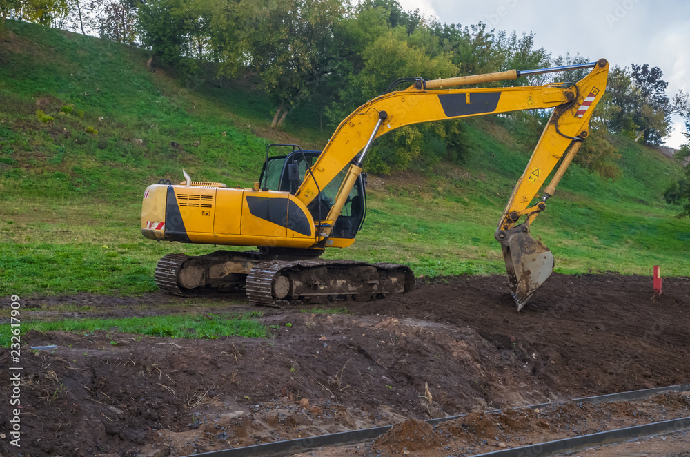 Yellow excavators on the construction of roads in the city park Yellow excavators on the construction of roads in the city park
