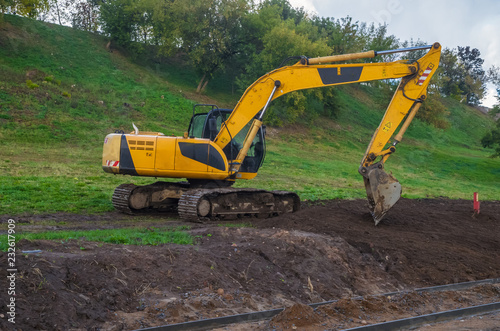 Yellow excavators on the construction of roads in the city park