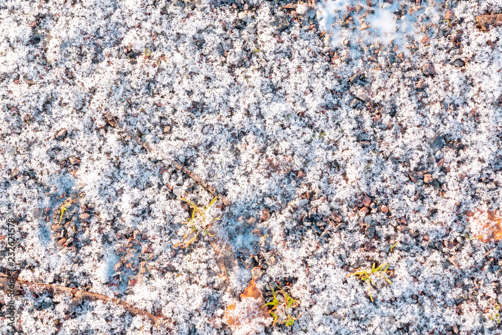 First light snow at the beginning of winter on surface of a gravel path. Symbol of the coming winter. Natural background texture First light snow at the beginning of winter on surface of a gravel path. Symbol of the coming winter. Natural background texture