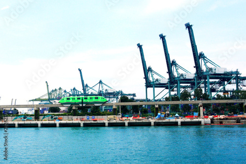 a light train passing heavy equipment near harbour