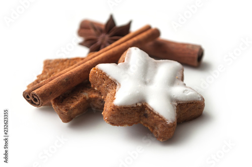 closeup of christmas biscuit shaped star with anise flower and cinnamon stick on white background