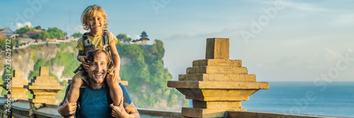 Dad and son travelers in Pura Luhur Uluwatu temple, Bali, Indonesia. Amazing landscape - cliff with blue sky and sea. Traveling with kids concept BANNER, LONG FORMAT