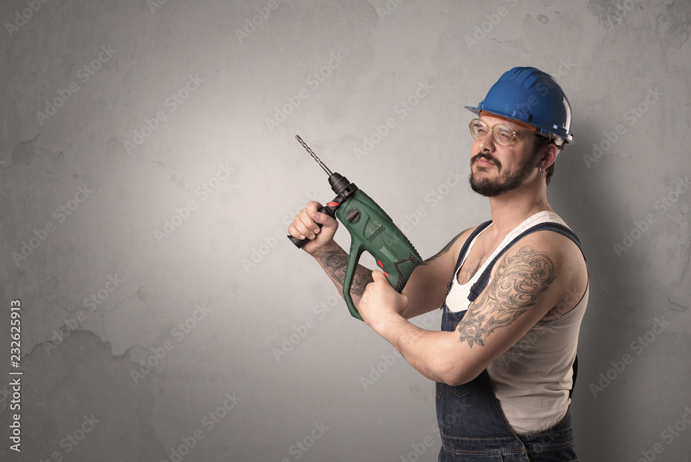 Craftsman standing in front of an empty wall with tool in his hand. Craftsman standing in front of an empty wall with tool in his hand.