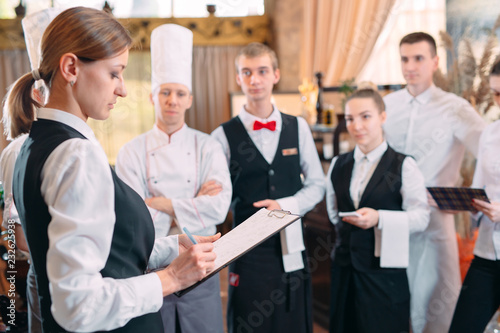 restaurant manager and his staff in kitchen. interacting to head chef in commercial kitchen.