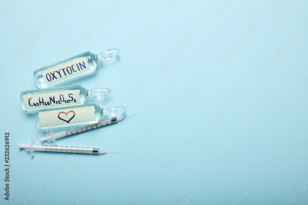 Obraz premium Oxytocin in ampoules. Decrease hormone and diagnostics. Heart and love concept. Copy space for text.