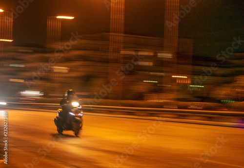 Foto Scooter moving at a road during night time