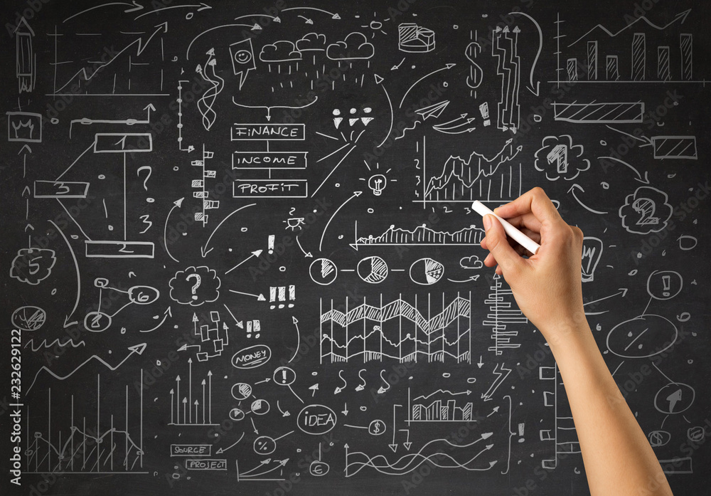 Female hand holding white chalk in front of a blackboard with a business plan drawn on it Female hand holding white chalk in front of a blackboard with a business plan drawn on it
