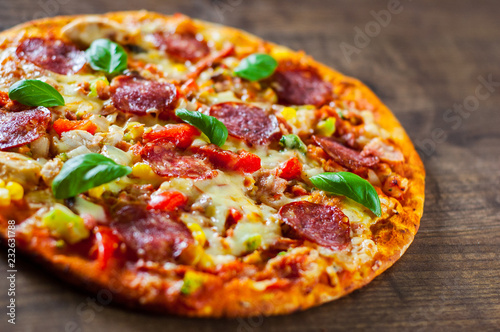 Pizza with Chicken meat, Mozzarella cheese, pepperoni, tomato, vegetables, salami. Italian pizza on wooden background