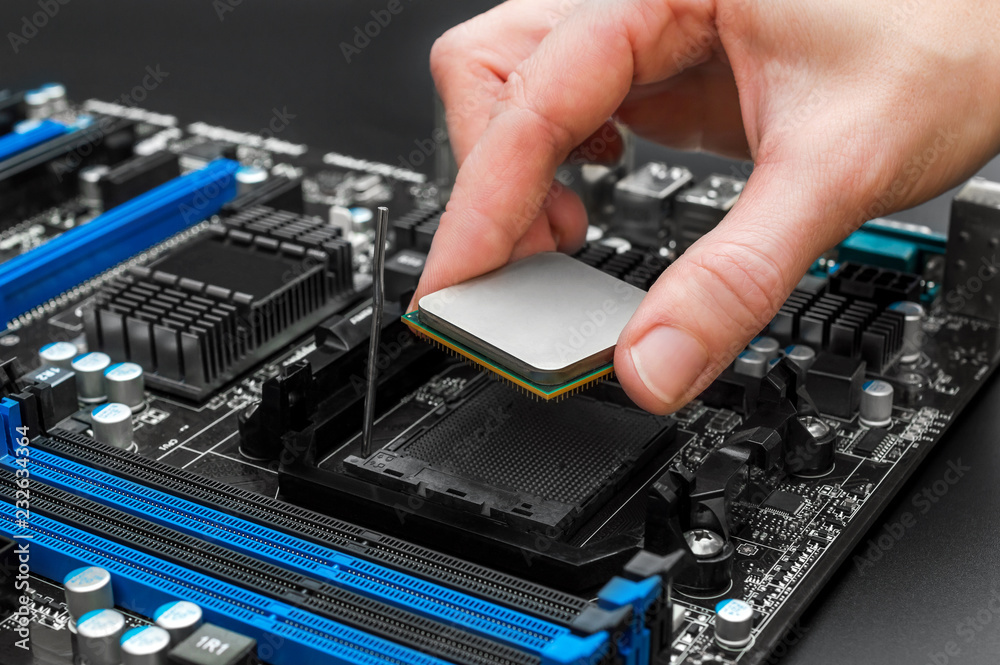 Hand puts computer processor on motherboard. Hand puts computer processor on motherboard.