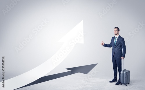 Young businessman hitchhiking with progressive arrow concept and copyspace
 photo