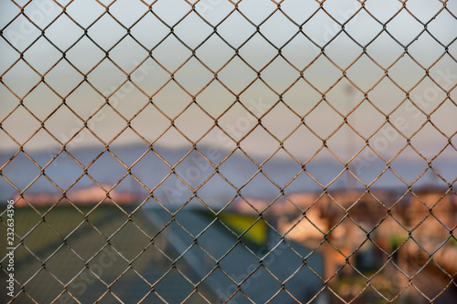 metal fence with mesh on background of blue sunset sky